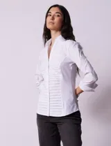 Camisa blanca de algodón marca Zac & Rachel, con cuello con solapa, abertura central con botones, delantera tableada y laterales elastizados.
