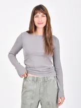 Remera de manga larga confeccionada en tejido de punto acanalado, con cuello redondo y calce ajustado al cuerpo.