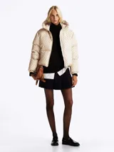 Campera acolchada con estampado distintivo en tonos beige y marrón. Cuenta con capucha fija, cuello alto, cierre de cremallera, bolsillos laterales y puños elásticos.