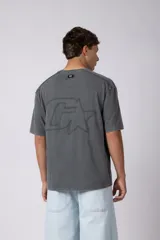 Remera de algodón gris con efecto acid wash, corte regular, mangas cortas y cuello redondo. Cuenta con un pequeño bordado tono sobre tono en el pecho y una etiqueta lateral distintiva de la marca en el ruedo.