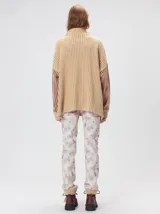 Pullover de tejido acanalado grueso con diseño bicolor en tonos marrón y bordó. Presenta cuello alto con cierre frontal, mangas largas y corte holgado.