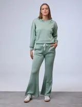 Conjunto deportivo verde agua compuesto por un hoodie de corte holgado con capucha y un pantalón acampanado con cordón ajustable en la cintura.