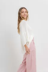 Sweater oversize de tejido liviano color blanco roto, con textura semi traslúcida, escote redondo y mangas amplias estilo murciélago.