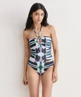 Malla entera con estampado abstracto en tonos negros, blancos, azules y verdes. Diseño halter con escote corazón y detalle de argolla en el centro del busto.