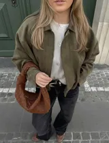 Campera bomber de corte oversized con efecto gamuza en color verde oliva. Presenta cuello clásico, cierre frontal y hombros estructurados con un diseño minimalista y relajado.