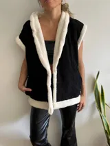 Chaleco negro de pana con interior y borde de corderito blanco.