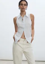 Camisa sin mangas con cuello clásico, cierre frontal con botones y diseño a rayas verticales en tonos celeste y blanco.