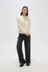 Sweater de punto color natural con diseño de ochos, cuello redondo y mangas largas de calce holgado.