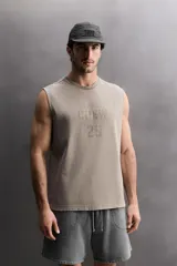 Musculosa de algodón con calce relajado y efecto lavado. Presenta cuello redondo, sisas amplias y estampado frontal con texto y logo a contraste.