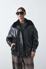 Campera de cuero sintético con acabado satinado, silueta relajada y elástico en la cintura. Presenta cuello con textura de piel sintética, cierre frontal y bolsillos laterales.