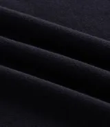 Remera de corte boxy en tejido crepé, color negro, con cuello polo en contraste color blanco y mangas cortas. Presenta un diseño holgado y moderno con textura sutil en la superficie.