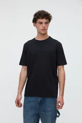 Remera de manga corta básica color negro, confeccionada en jersey de algodón de textura suave, con cuello redondo y calce clásico.