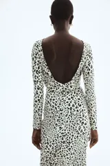 Vestido midi entallado de punto con estampado de leopardo, cuello redondo, manga larga y espalda descubierta con detalle cruzado en la cintura.