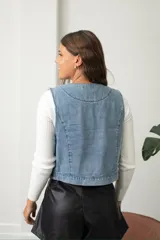 Chaleco de jean con bordados étnicos y detalles de lentejuelas, de corte entallado y cierre frontal.