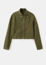 Chaqueta estilo militar color verde militar, confeccionada en algodón, con cuello alto, cierre frontal de cremallera y doble botonadura metálica decorativa.