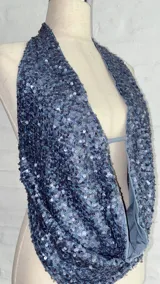 Top con escote halter y espalda descubierta, confeccionado en tela con lentejuelas azules.