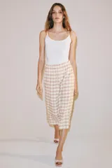 Falda midi recta de tiro medio con estampado a cuadros en tonos rosados y blancos sobre base beige, confeccionada en hilatura con mezcla de viscosa. Cuenta con cintura elástica ajustable con cordones y bajo recto.
