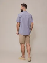 Camisa de manga corta con rayas verticales azules y blancas, confeccionada en algodón.