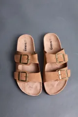 Sandalias Brokers Wear de color beige, con dos tiras ajustables con hebillas metálicas doradas y plantilla anatómica.