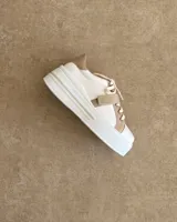 Sneakers de mujer estilo deportivo y urbano, color negro con detalles en beige claro. Presentan puntera y talón en negro, cuerpo principal en negro, y estrella lateral, cordones y tira de velcro en beige claro. La suela es blanca y el interior negro con la inscripción "LUCY IN THE SKY".