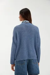 Sweater de tejido de punto con textura tipo esterilla, color azul piedra, con escote en V y mangas largas de corte holgado.