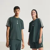 Camiseta de punto oversized verde oscuro de la colección Icons de Adidas, inspirada en los años 80, con rayas diplomáticas blancas, las icónicas tres tiras de la marca en las mangas, cuello redondo y el logotipo del trébol bordado junto al escudo vintage de la Juventus.