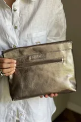 Sobre de mano color bordó en cuero charolado, con solapa frontal decorada con una piedra ágata natural engarzada. Incluye correa larga extraíble y cierre trasero.