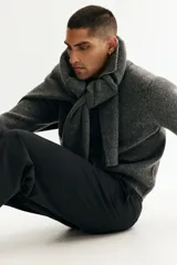 Pantalón de traje de corte relajado, con diseño de rayas finas, cierre oculto, pinzas delanteras y piernas rectas.