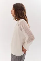 Sweater de tejido de punto calado color lila, con cuello en V y mangas largas.