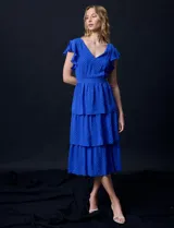 Vestido blanco de gasa con capas, marca Julia Jordan. Escote en V, manga corta con volados, corte en cintura y abertura central en espalda con cierre invisible.