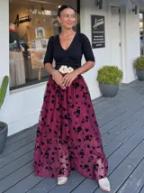 Falda larga de tul en color canela con bordados de flores negras. Presenta una silueta amplia y fluida, ideal para eventos formales.