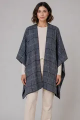 Ruana abierta de corte amplio con diseño de cuadros en tonos grises y negros. Presenta una caída fluida y terminaciones simples, ideal para superponer sobre otras prendas.