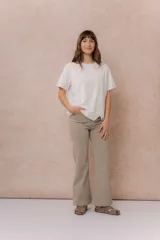 Pantalón de jean color arena, de corte flare con pierna levemente acampanada y tiro medio. Cuenta con cierre frontal, botón, pasacintos y bolsillos funcionales.