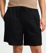 Bermuda masculina de sarga texturizada en color negro, con cintura elástica y ajuste mediante cordón. Presenta un corte regular, bolsillos laterales y un bolsillo trasero aplicado.