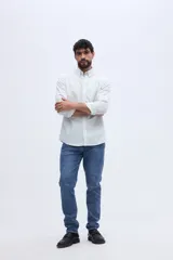 Camisa de manga larga color blanco, de corte regular, con cuello abotonado y bolsillo frontal en el pecho.