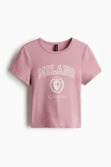Remera de algodón de corte entallado, con cuello redondo y mangas cortas. Presenta un estampado frontal con la inscripción 'MILANO ACADEMIA' y un escudo universitario.