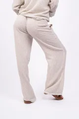 Pantalón largo de mujer, de corte amplio y tiro alto, con estampado a rayas verticales en tonos beige y blanco. Tiene cintura elástica con cordón ajustable.