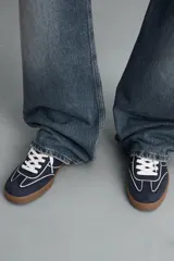 Zapatillas deportivas de hombre, color azul marino, con detalles en blanco y suela color caramelo.