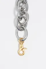 Collar maxi de cadena con eslabones circulares entrelazados de acabado plateado mate y cierre de mosquetón dorado.