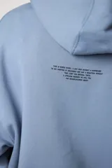 Buzo hoodie celeste con cordones ajustables, bolsillo tipo canguro y puños elásticos. Estampado frontal con dibujo de surfista y texto "blue bananas".