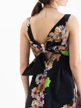 Vestido maxi negro con estampado floral, silueta en A, escote cuadrado con bandeau superpuesto y lazo en la espalda.