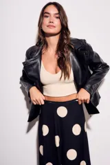 Campera negra estilo biker confeccionada en cuero vegano, con cuello solapa, cierre asimétrico y bolsillos con cremallera.