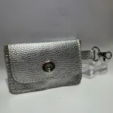 Tarjetero pequeño de cuero sintético plateado con cierre de broche a presión y gancho metálico.