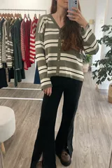 Cárdigan tejido a rayas horizontales en tonos verde militar, blanco y negro, con cuello en V y cierre frontal con botones marrones.