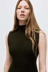 Vestido corto sin mangas confeccionado en tejido de punto fino acanalado, con cuello tortuga bajo, cuerpo entallado y falda con leve vuelo.