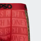 Calzoncillos tipo bóxer de color rojo con estampado de texto "PSD $$$ RICH MONEY" y banda elástica roja con logo PSD en negro. Diseño con ribete inferior con motivos barrocos en dorado y negro.