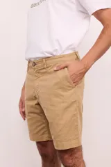 Bermuda de vestir de gabardina color azul marino, de corte regular, con bolsillos laterales y traseros, y cierre frontal con botón y cremallera.