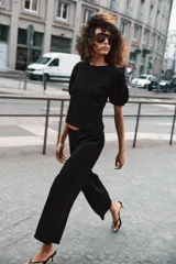 Top de algodón color negro con cuello redondo y mangas cortas abullonadas con terminación elástica.