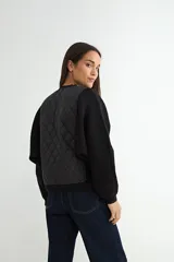 Campera tipo bomber con frente acolchado en diseño de rombos y mangas de tejido de punto acanalado. Presenta cierre frontal metálico y cuello, puños y ruedo en tejido elástico.