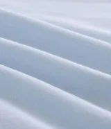 Remera boxy de algodón color celeste, con cuello redondo y mangas cortas. Presenta un estampado frontal con lettering y un estampado trasero grande con un corazón formado por círculos coloridos y una pequeña ilustración de una casa debajo, inspirado en la película "Up: Altas Aventuras".